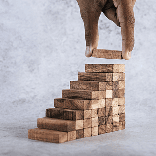 Wooden blocks arranged as ascending stairs representing growth