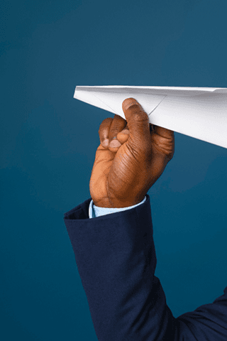 Hand launching a paper airplane representing vision